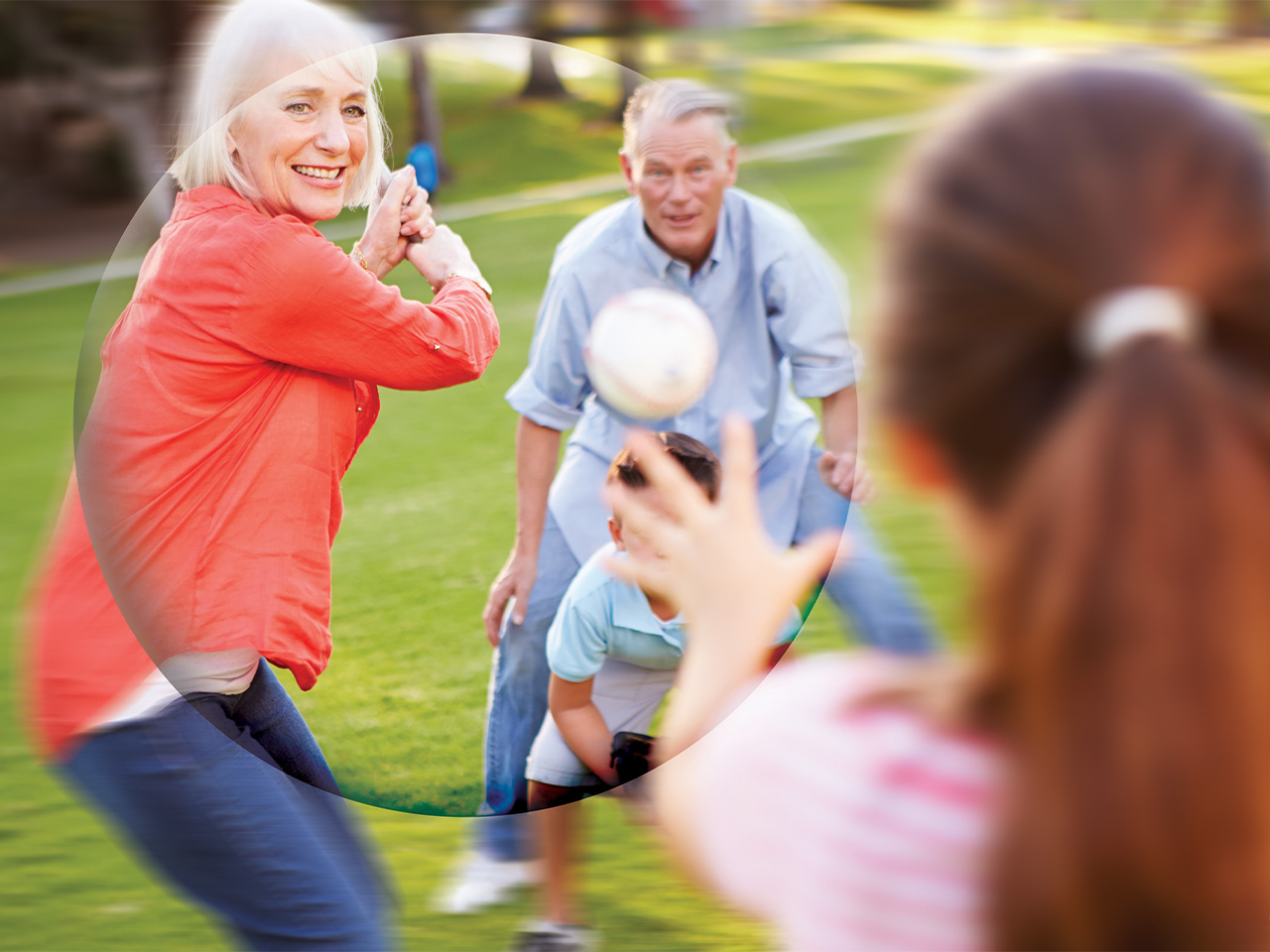 Frau mit rotem Oberteil spielt Baseball mit Kindern